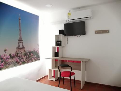 1 dormitorio con escritorio y silla roja en Hotel 42 Avenida, en Palmira