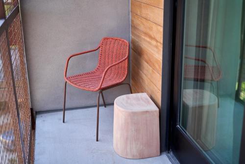 a red chair sitting on a porch next to a building at Hotel Magdalena in Austin