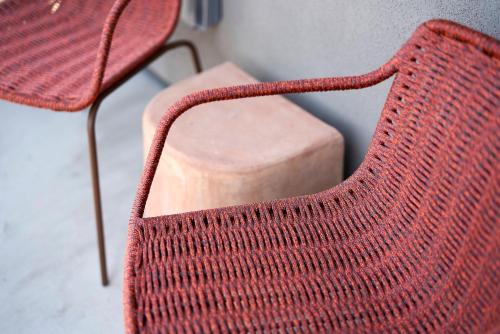 a red knitted chair next to a wooden block at Hotel Magdalena in Austin