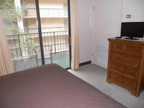 a bedroom with a bed and a television and a balcony at Oak Square 210 in Gatlinburg