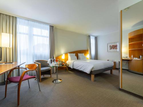 Habitación de hotel con 1 cama, escritorio y 1 dormitorio en Novotel Mainz en Mainz