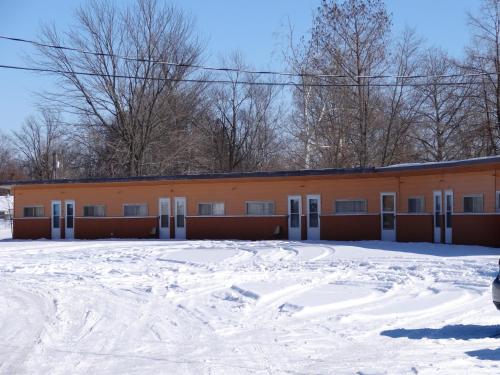 un edificio naranja con nieve delante en Sparta Motel en Sparta