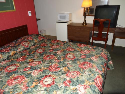 Habitación de hotel con cama con colcha floral en Sparta Motel en Sparta