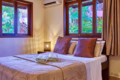 een slaapkamer met een bed met twee handdoeken erop bij Pipa Beleza Melhores Aparts in Pipa