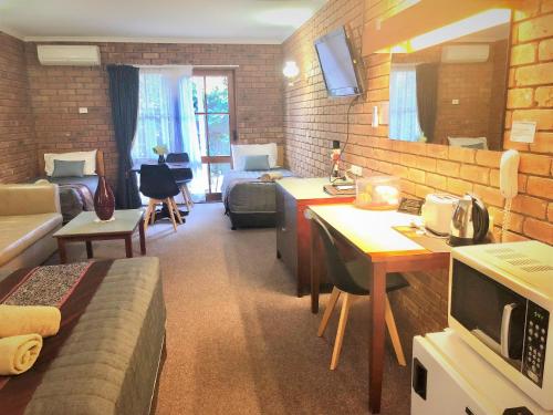 a living room with a couch and a living room with a couch at Jolly Swagman Motor Inn Euroa in Euroa