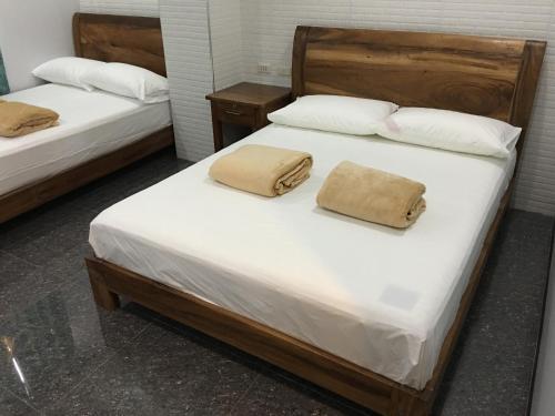 2 camas en una habitación con sábanas y almohadas blancas en Lucena Fresh Air Hotel, en Lucena