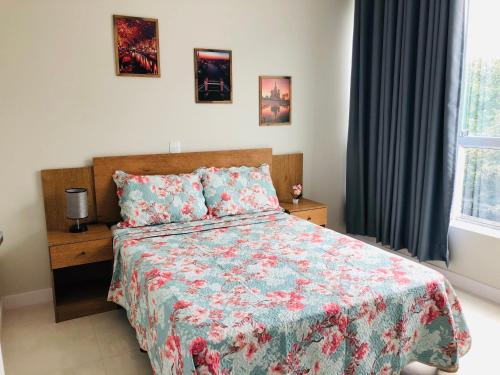 a bedroom with a bed with a floral bedspread at Residencial Spader - Bombinhas in Bombinhas