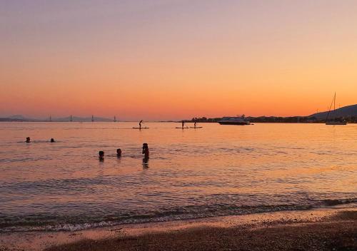 a group of people in the water at sunset at Hotel Nafpaktos in Nafpaktos