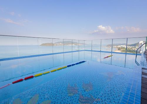 a swimming pool with a view of the ocean at Masova Hotel in Nha Trang