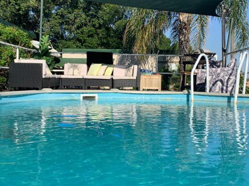 a swimming pool with a couch and a swimming pool at Evanston Station in Ilfracombe