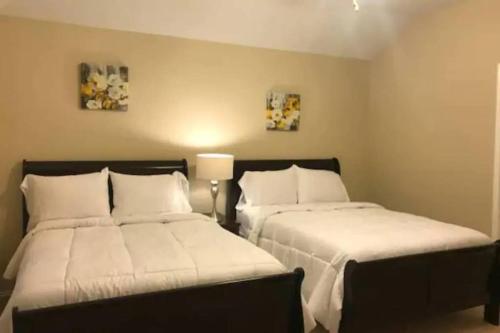 1 dormitorio con 2 camas con sábanas blancas en Spacious 3 bed/ 2 bathroom House in Conroe, TX, en Conroe
