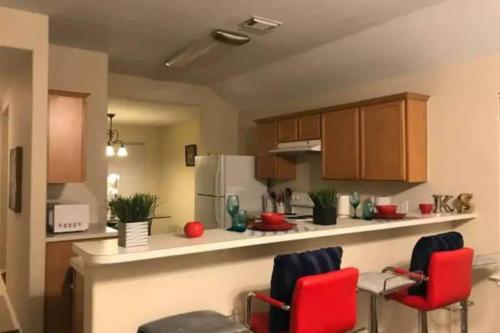 a kitchen with two red chairs and a counter at Spacious 3 bed/ 2 bathroom House in Conroe, TX in Conroe