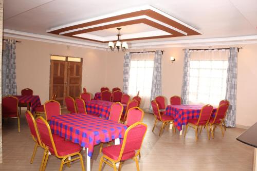 einen Konferenzraum mit roten und blauen Tischen und Stühlen in der Unterkunft Villa Serene Hotel in Kitale