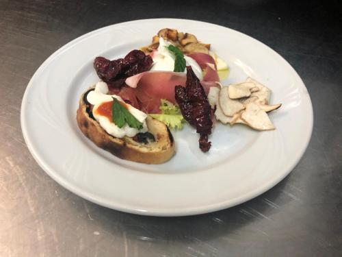 a plate of food with a sandwich on a table at Hotel Pietrapanna in Calvello