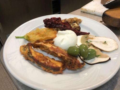 a plate of food with meat and vegetables on a table at Hotel Pietrapanna in Calvello