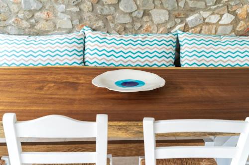 a wooden table with two white chairs and pillows at Almira Hotel in Troulos
