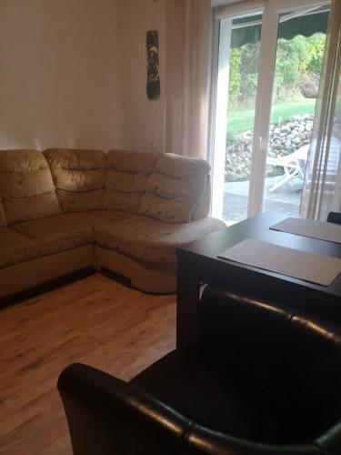 a living room with a couch and a table at Dom wczasowy Rychertówka in Grzebieniec