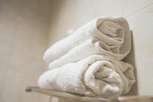 a pile of towels on a shelf in a bathroom at City Residence Kutai 32 in Surabaya