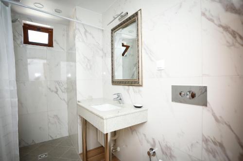 ein weißes Badezimmer mit einem Waschbecken und einem Spiegel in der Unterkunft Родопчани Старцево in Starzewo