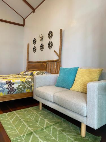 a living room with a couch and a bed at One khaokho homestay in Khao Kho