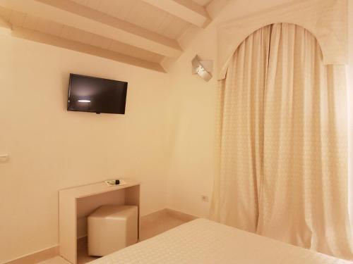 sypialnia z łóżkiem i telewizorem na ścianie w obiekcie Hotel Azzurra w mieście Lido degli Estensi