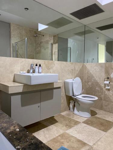 a bathroom with a white toilet and a sink at The Franklin Luxury Apartments in Johannesburg