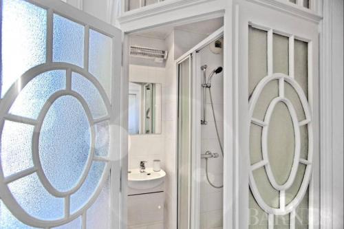 a white bathroom with a sink and a mirror at Magnifique Appartement dans palace Belle Époque in Aix-les-Bains