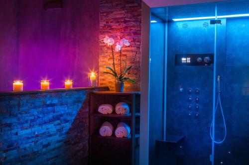 een badkamer met een douche met paarse verlichting en kaarsen bij Di Sabatino Resort - Suite Apartments & Spa in Ascoli Piceno