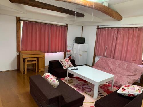 a living room with a couch and a table at 民泊はのこの庭 in Kokuryō