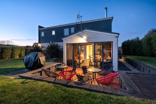 a house with a patio with chairs and a table at Madsen Retreat in Penguin