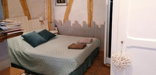 Un pequeño dormitorio con una cama con toallas. en Le Relais de La Myrpe, en Bergerac