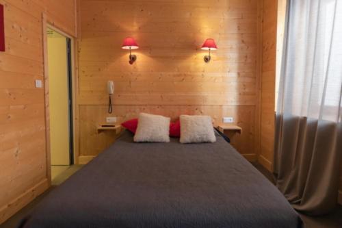 a bedroom with a bed with two pillows on it at Hotel le Sacca, nouvelle équipe in Cauterets