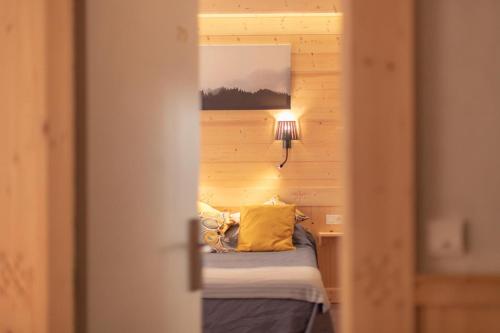 a view of a bedroom with a bed and a lamp at Hotel le Sacca, nouvelle équipe in Cauterets