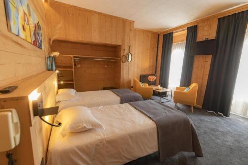 a hotel room with two beds and a desk at Hotel le Sacca, nouvelle équipe in Cauterets