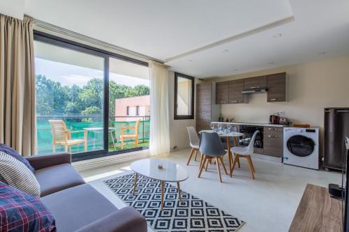 un salon avec un canapé et une table avec des chaises dans l'établissement Beau 2 pièces Evry Centre, Évry-Courcouronnes