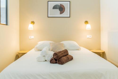 une chambre avec un lit blanc avec des serviettes dessus dans l'établissement Beau 2 pièces Evry Centre, Évry-Courcouronnes