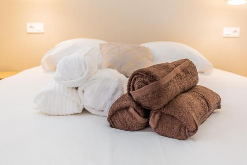une pile de serviettes posée sur un lit dans l'établissement Beau 2 pièces Evry Centre, Évry-Courcouronnes