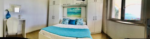 Habitación pequeña con cama con almohadas azules en Lux Apartments, en Korčula