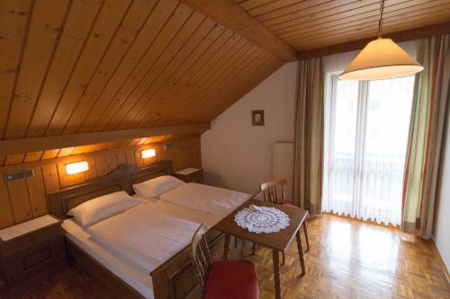 a bedroom with a bed and a table in it at Ferienhof Alte Post, Apartments in Weissbriach