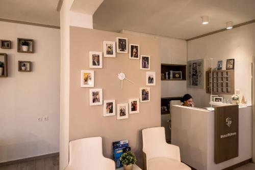 a woman sitting at a counter in a room with pictures on the wall at Kokona in Symi