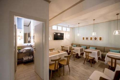 een eetkamer met witte tafels en stoelen bij Kokona in Symi