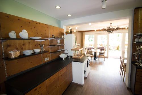 a kitchen with a counter and a dining room at Ferienhof Alte Post, Apartments in Weissbriach