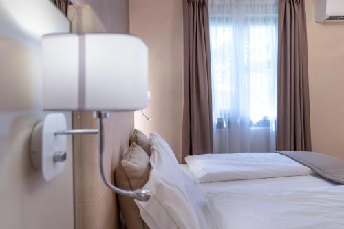 a hotel room with a bed and a lamp at Park Hotel Imperial in Limone sul Garda