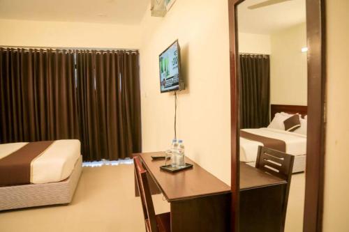 una camera d'albergo con specchio, scrivania e letto di Hotel Golden Hill a Cox's Bazar