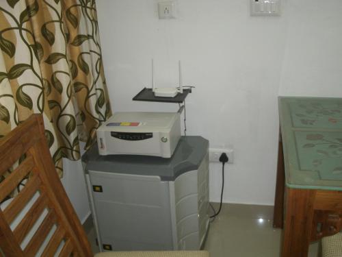 a printer sitting on top of a table in a room at Jacaranda Holiday Home in Cochin