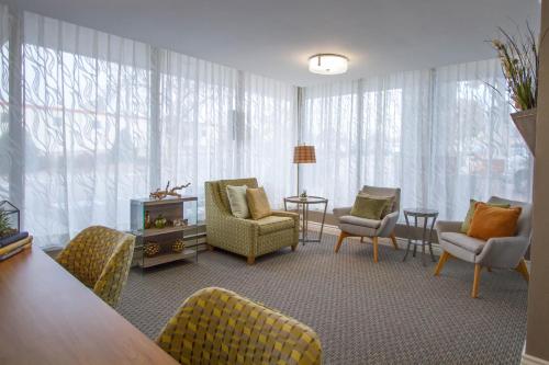 a living room with chairs and a table at Holiday Inn Bloomington Airport South-Mall Area by IHG in Bloomington