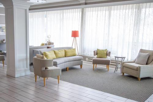 a living room with a couch and chairs and a table at Holiday Inn Bloomington Airport South-Mall Area by IHG in Bloomington