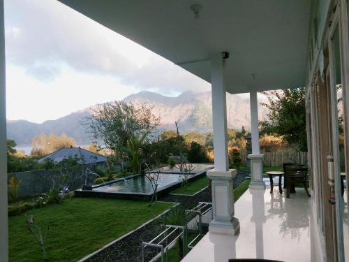 a porch of a house with a view of a garden at Batur Pyramid Guesthouse in Kintamani