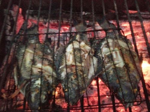a bunch of food cooking on a grill at Batur Pyramid Guesthouse in Kintamani