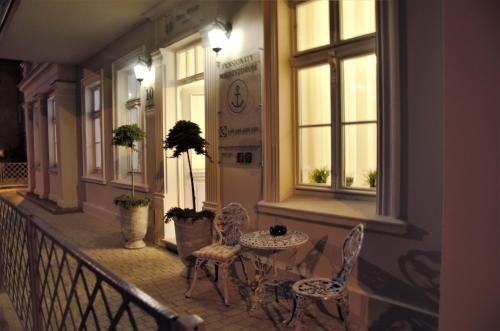 a porch with a table and chairs on a balcony at Dwie Wieże in Międzyzdroje